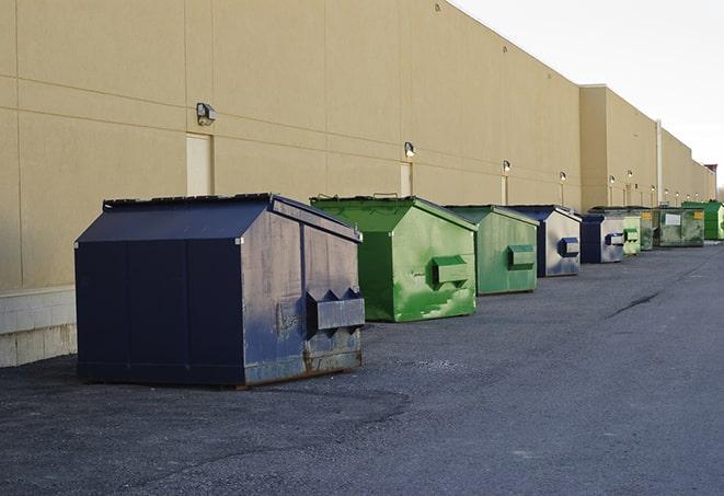 a row of yellow and blue dumpsters at a construction site in Carpentersville, IL